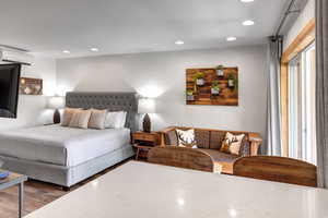 Bedroom featuring recessed lighting, wood finished floors, and a wall mounted air conditioner