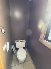 Bathroom with light tile patterned flooring and toilet