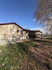 View of side of home featuring a yard and a wooden deck