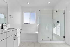 Bathroom with a garden tub, vanity, and a stall shower