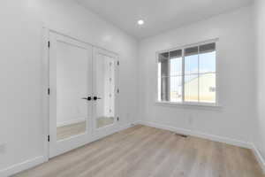 Unfurnished bedroom featuring a closet, light wood-type flooring, and recessed lighting