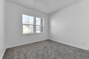 Carpeted empty room with baseboards