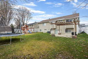 Back of house with a trampoline, a pergola, a fenced backyard, a patio area, and a playground