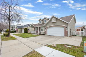 Traditional home featuring concrete driveway, brick siding, a shingled roof, an attached garage, and covered porch