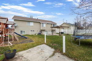 Back of property featuring a trampoline, a playground, a patio, and a pergola