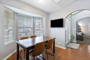 Dining space featuring wood finished floors and arched walkways