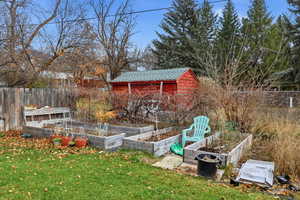 View of yard featuring a vegetable garden and a storage shed