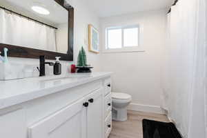 Full bath featuring curtained shower, vanity, and light wood-type flooring