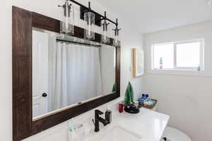 Bathroom featuring a shower with shower curtain and vanity