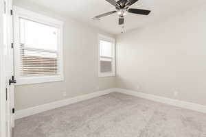 Unfurnished room featuring carpet flooring and a ceiling fan