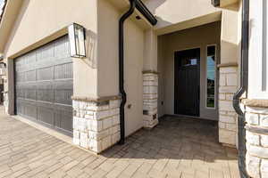 Entrance to property featuring stucco siding and stone siding