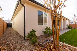 View of side of home with a fenced backyard, stucco siding, and a patio area