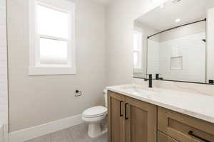 Full bathroom with light tile patterned floors, vanity, and a shower
