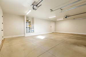 Garage featuring water heater and a garage door opener