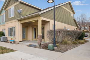 View of side of home with stucco siding and covered porch