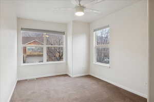 Empty room featuring carpet flooring and ceiling fan