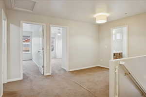 Corridor with light colored carpet and an upstairs landing