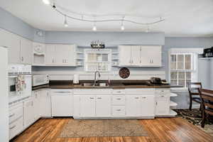 Kitchen with open shelves, white appliances, white cabinets, and a textured ceiling