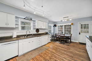 Kitchen with open shelves, dishwasher, white cabinetry, and plenty of natural light