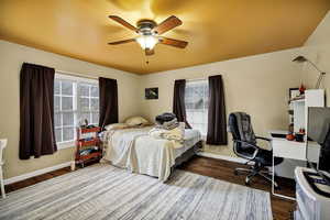 3rd Bedroom with a ceiling fan, multiple windows, a desk, and dark wood-style flooring
