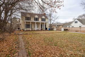 View of front facade featuring a chimney and covered porch