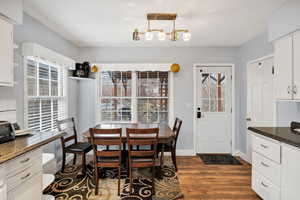 Dining space featuring dark wood-style flooring and baseboards