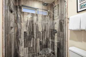 Full bathroom with a shower stall and toilet