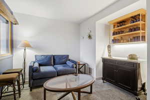 Living area with light colored carpet and baseboards