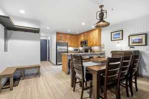 Dining room with light wood-style flooring, recessed lighting, and electric panel