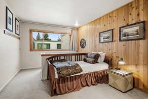 Bedroom with carpet and wood walls