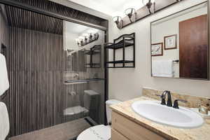 Full bath featuring a shower stall and vanity