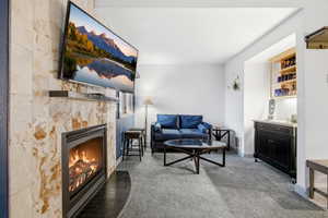 Living area featuring a tile fireplace and carpet flooring
