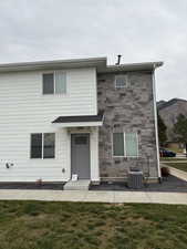 View of front facade with a front yard and stone siding