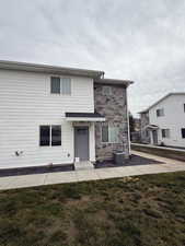 View of front of property with a front lawn and stone siding