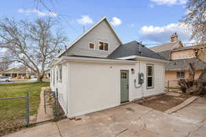 Rear view of property featuring a gate and a shingled roof