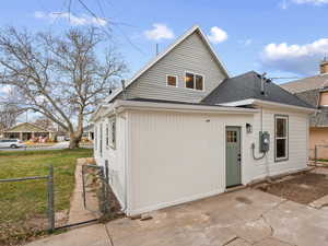 Rear view of property featuring a gate and a shingled roof