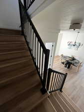Stairway featuring wood finished floors and a textured ceiling