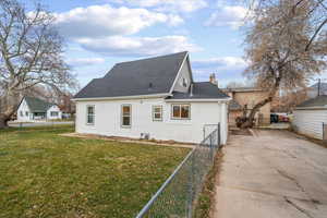 View of home's exterior featuring a shingled roof, concrete driveway, and a chimney