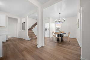 Dining area featuring a chandelier, light wood-type flooring, and stairs