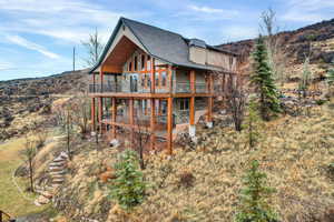 Back of house featuring stone siding, stucco siding, and a mountain view