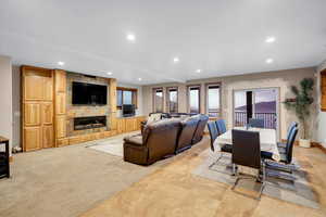 Living room with recessed lighting, a large fireplace, and light carpet