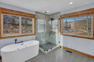 Full bath featuring a stall shower, a soaking tub, a mountain view, and recessed lighting