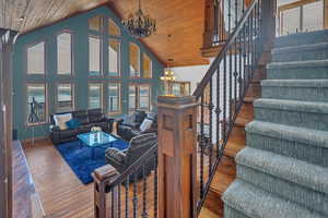 Living room with a chandelier, hardwood / wood-style flooring, and a high wood ceiling