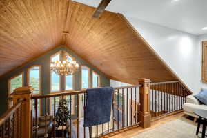 Living area with wood ceiling, a chandelier, wood finished floors, and vaulted ceiling