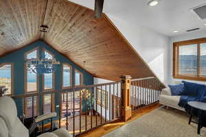 Corridor featuring wood-type flooring, a vaulted wooden ceiling, and suspended lighting