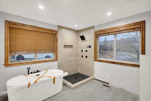 Bathroom with a soaking tub, tiled shower, and recessed lighting