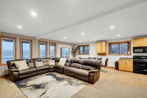 Living room with recessed lighting, beamed ceiling, and light colored carpet