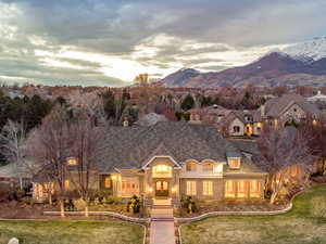 French country home with stone siding, a front yard, and a mountain view