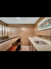 Bar with light countertops, wood walls, and a textured ceiling