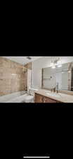 Full bathroom featuring vanity, shower / bath combination with curtain, and a chandelier
